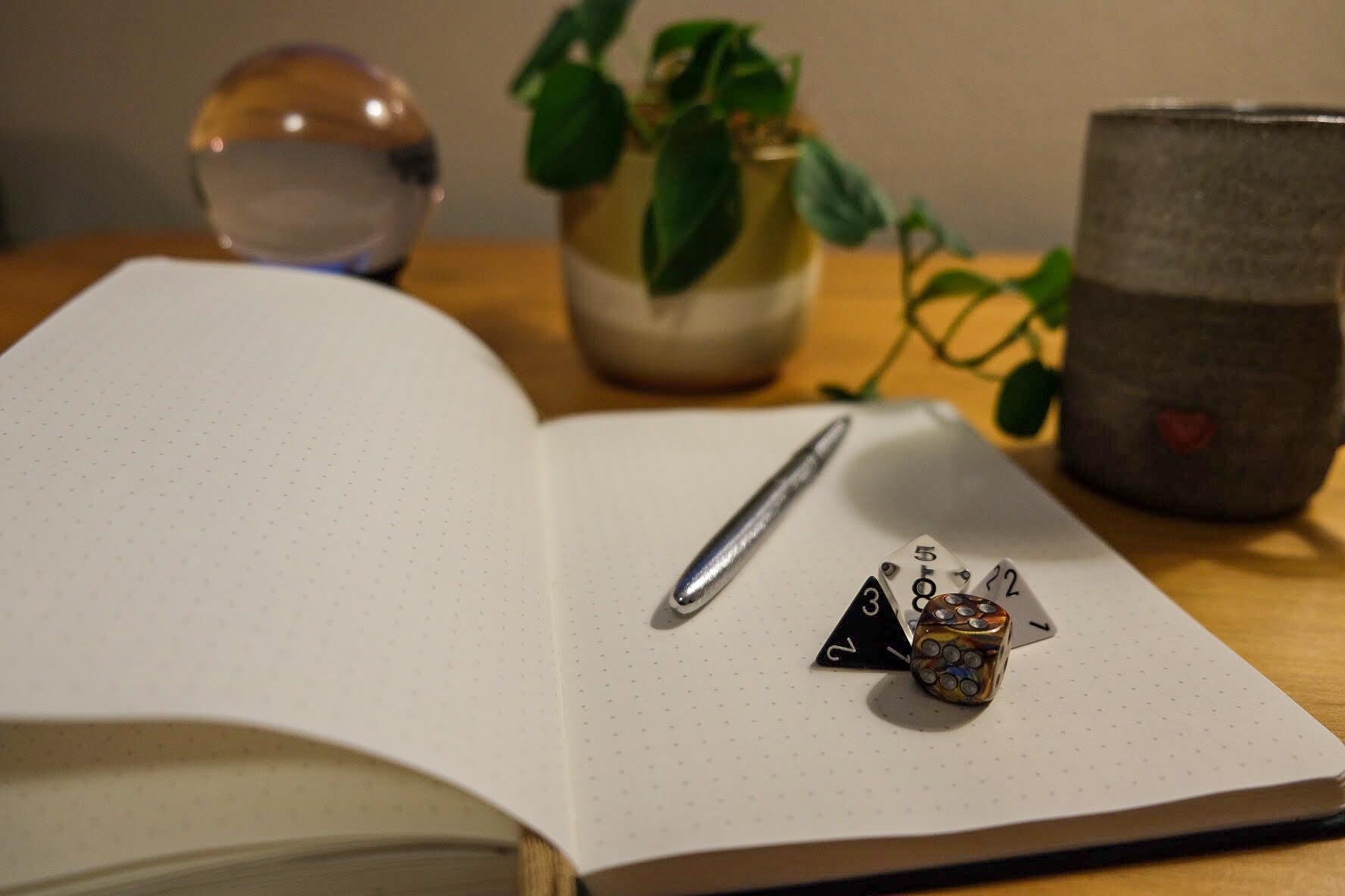 Playheart dice beside an open journal